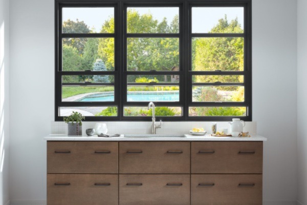 dark window frame looking out to backyard pool from bathroom